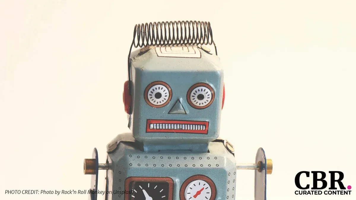 A vintage tin toy robot with a coiled metal antenna against a plain background