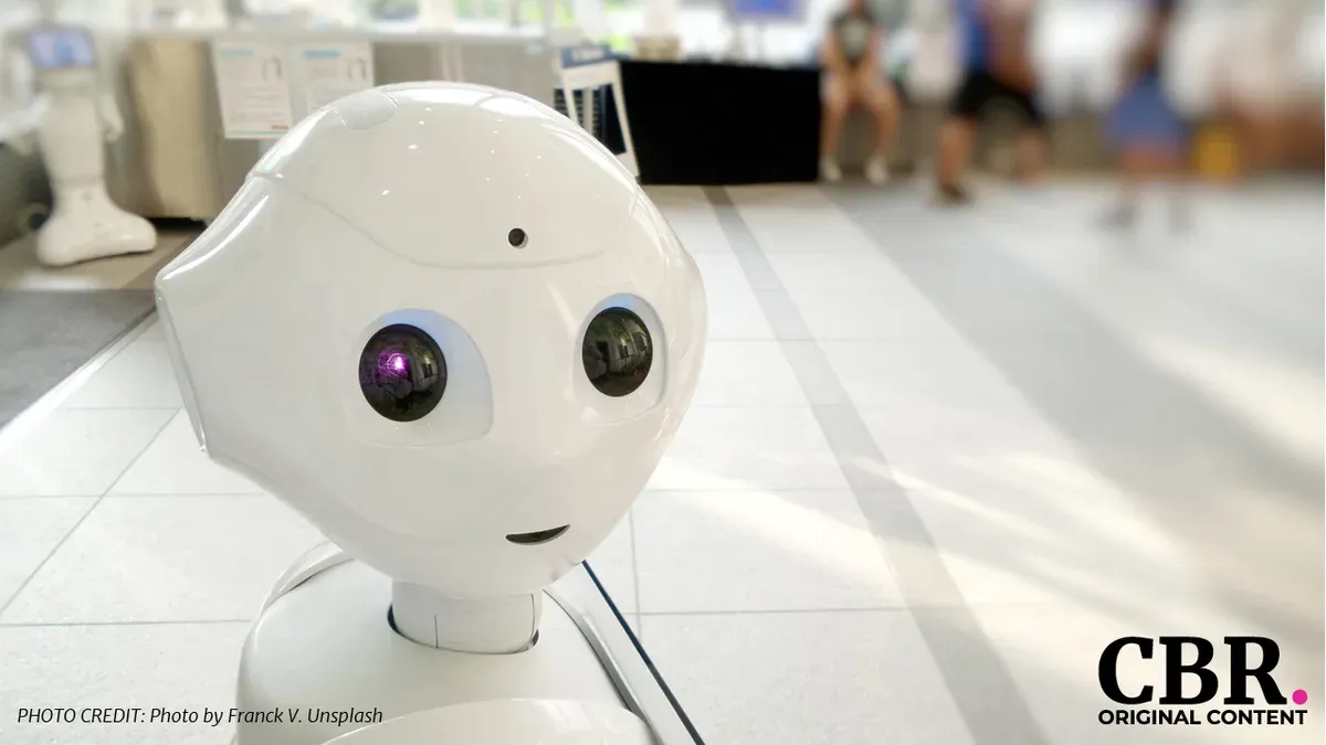 A white humanoid service robot in an indoor public space
