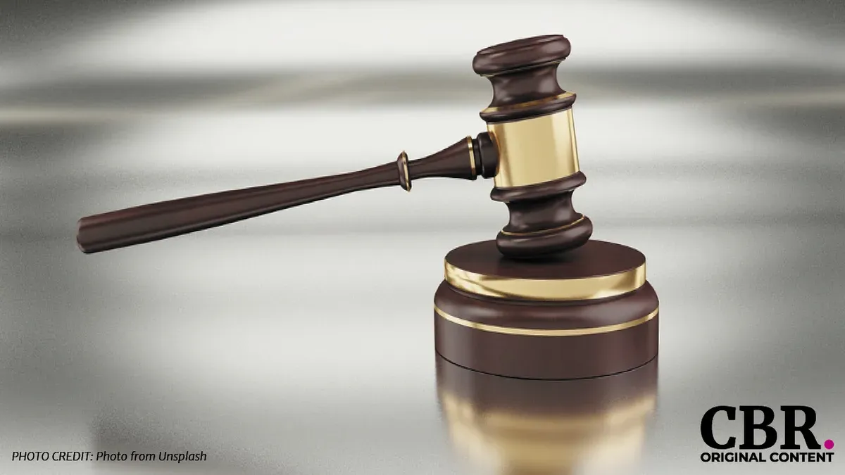A wooden gavel resting on its stand
