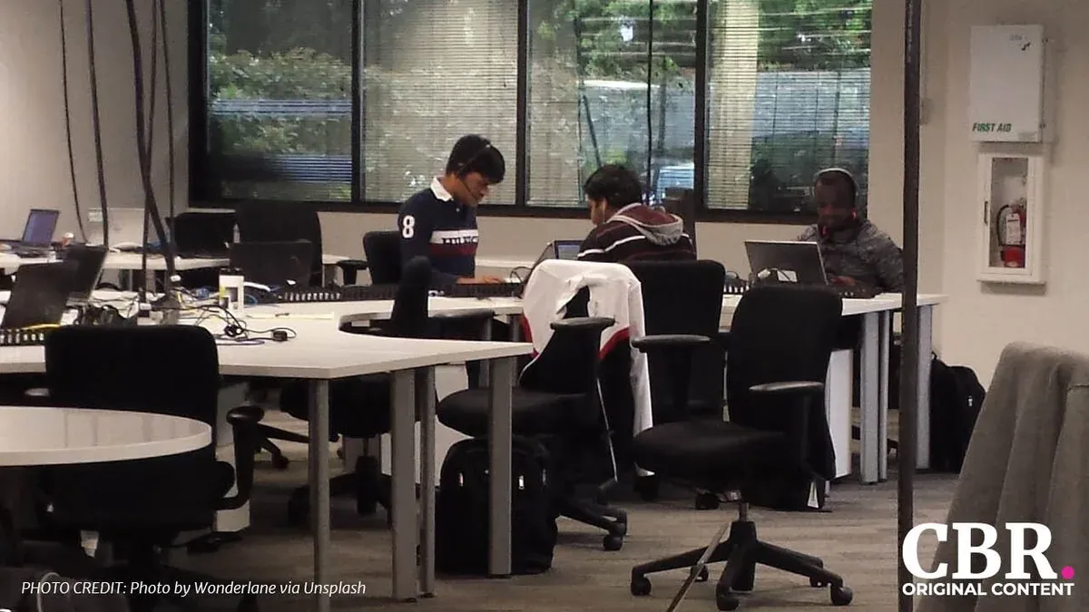 An open-plan office with people working at laptops