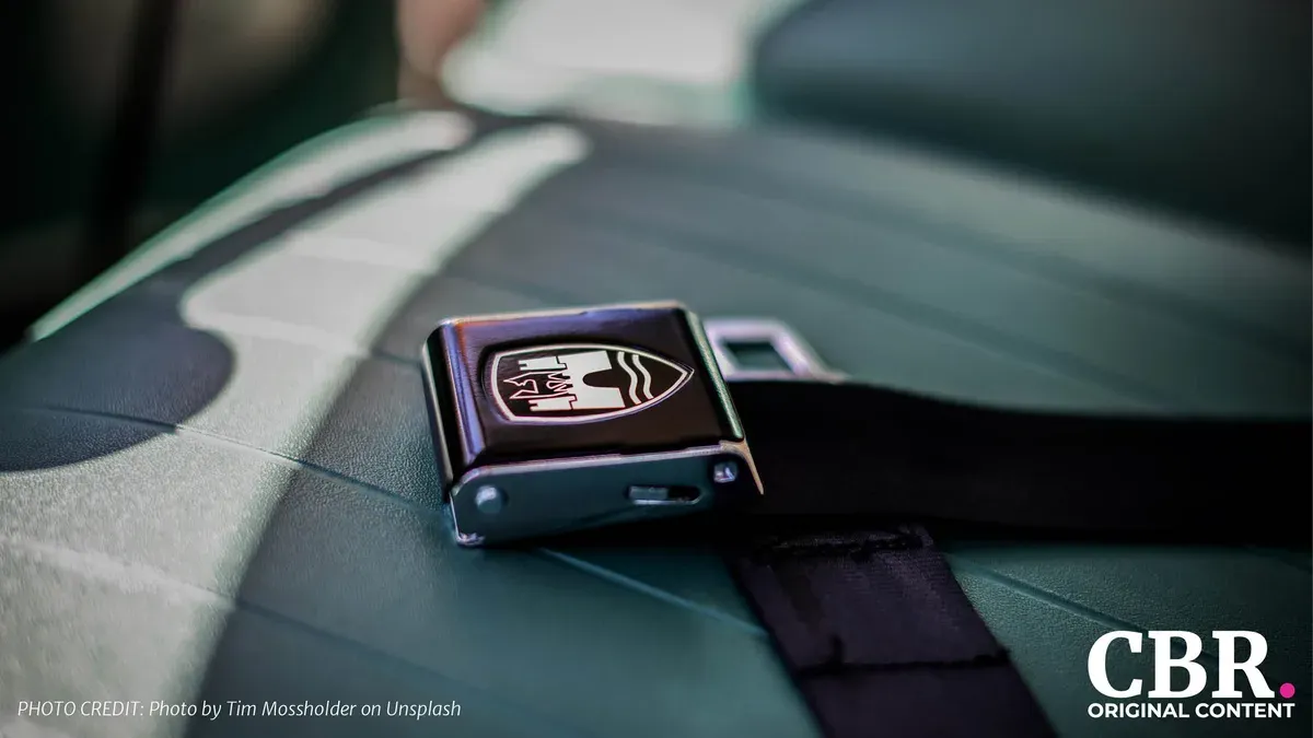 A car seatbelt buckle resting on a leather seat