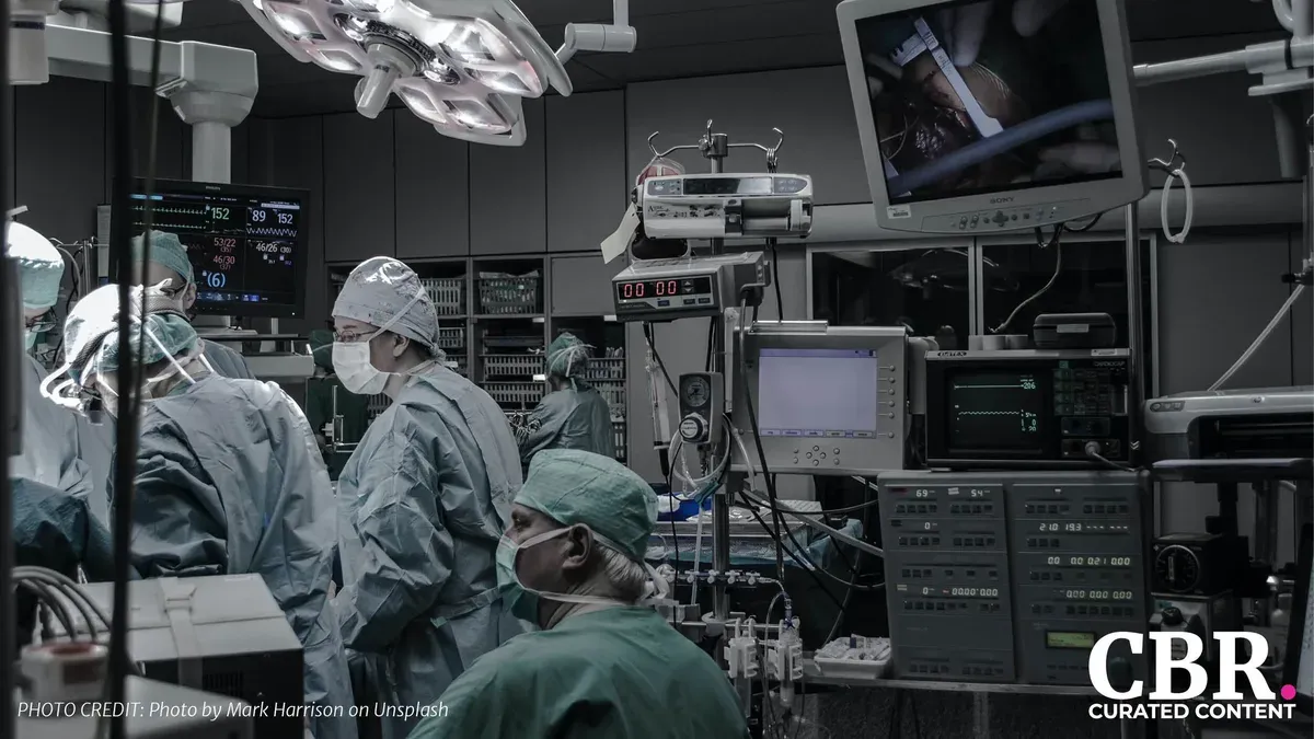 Medical staff in an operating room surrounded by monitors and equipment during a procedure