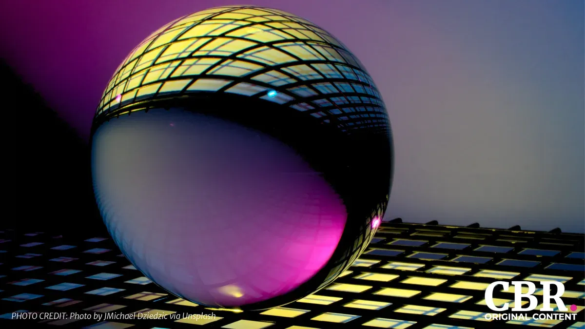 A reflective glass sphere resting on an illuminated grid, lit in purple and gold